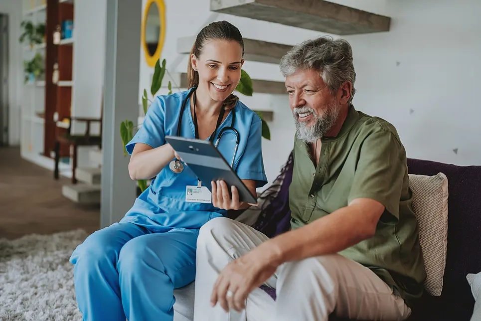 Nurse reviewing results on a tablet with an older male patient