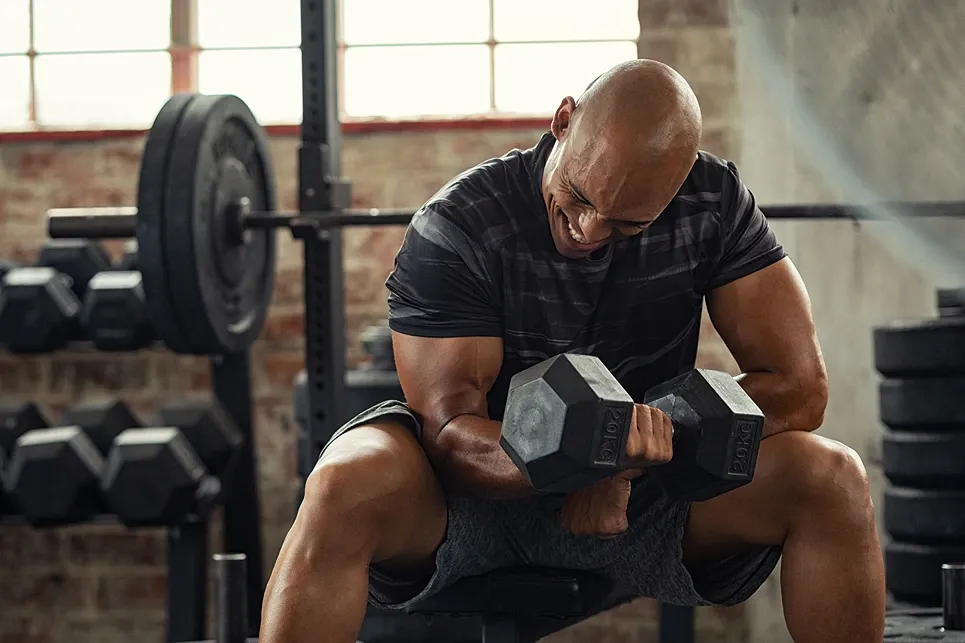Man doing dumbbell curls in a gym