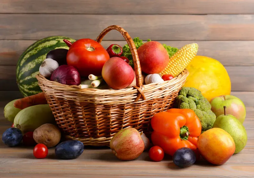 Fresh organic fruits and vegetables on wooden background