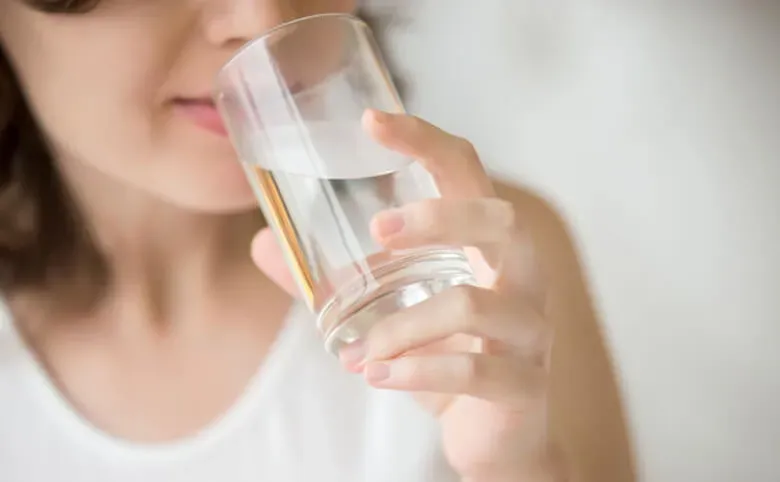 woman holding a glass of water
